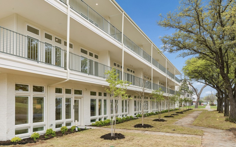 exterior of multilevel building with newly planted trees