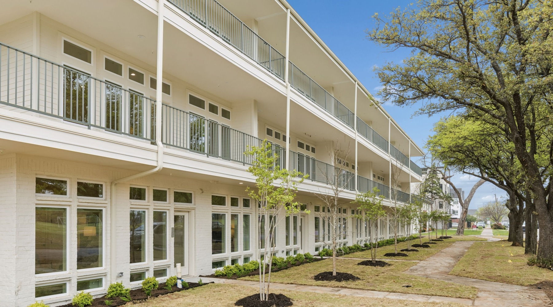 exterior of multilevel building with newly planted trees