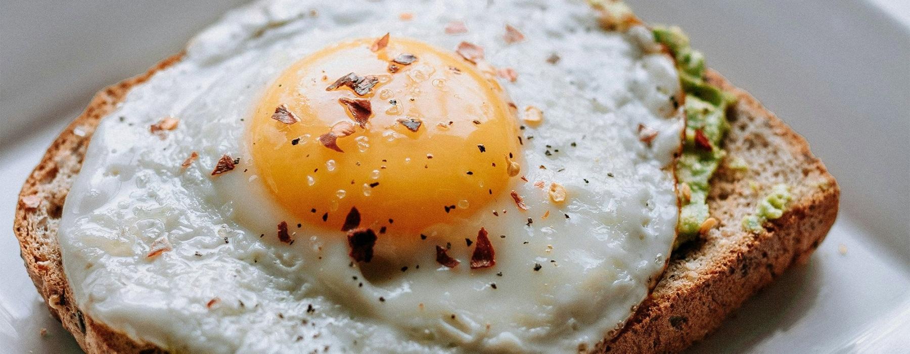 a breakfast sandwich with an egg on top