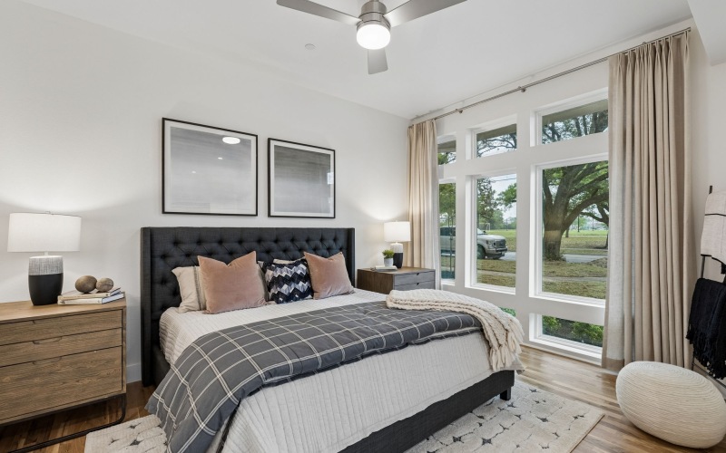 bedroom with bed lampsand large windows
