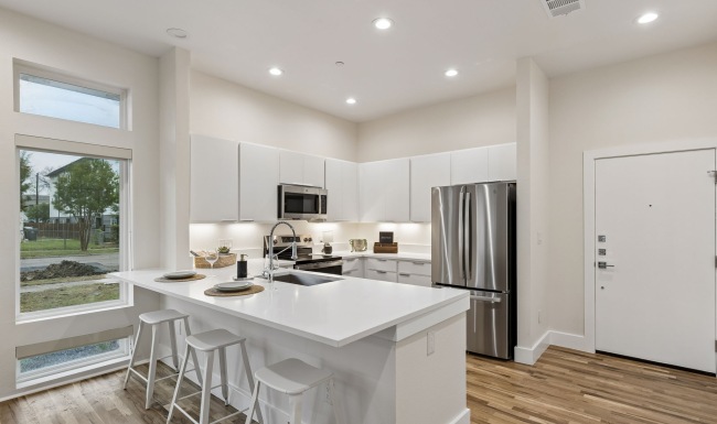 kitchen with wood flooring and white cabinets 