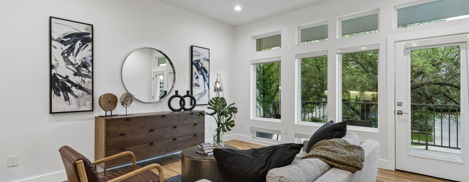 living room with a couch coffee table  mirror and large windows