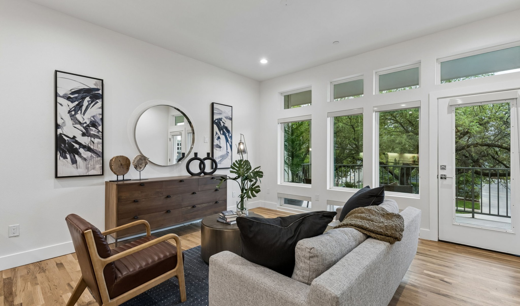living room with a couch coffee table  mirror and large windows